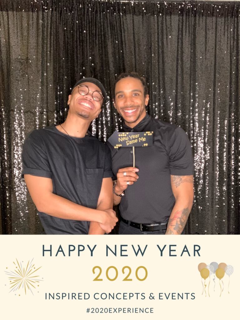 A smiling couple in a new year's party photobooth