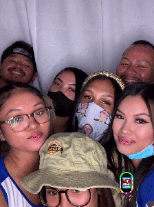 A friend group posing at a custom event photobooth
