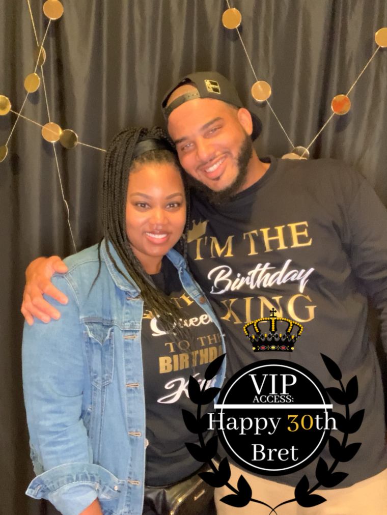 A happy couple in a 30th birthday party photobooth